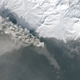 This picture of Kambalny’s ash plume flowing was captured on March 28 by the NASA Landsat 8 satellite. In the lower half of the picture, what is likely white snow (like you can see in the top half) is obscured by gray smoke and ash. (NASA Earth Observatory/Landsat 8)
